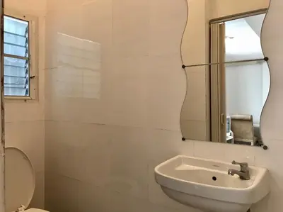 a white bathroom with a sink and a mirror at 12/14 HOME Studio in Bangkok