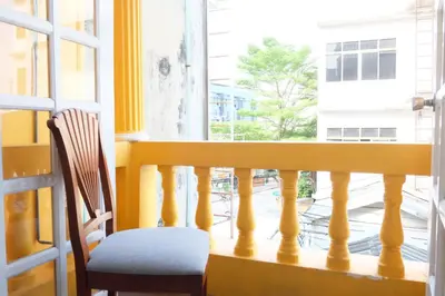 a chair sitting on a balcony looking out a window at 12/14 HOME Studio in Bangkok