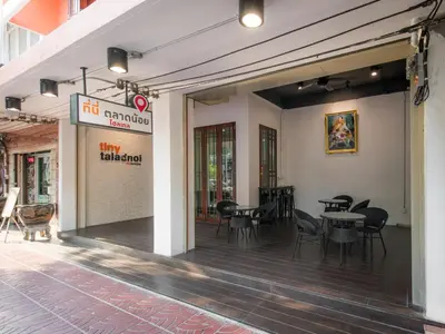 a patio with chairs and tables in a building at Tiny Taladnoi Hostel in Bangkok