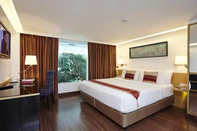 a hotel room with a large bed and a window at Citypoint Hotel in Bangkok