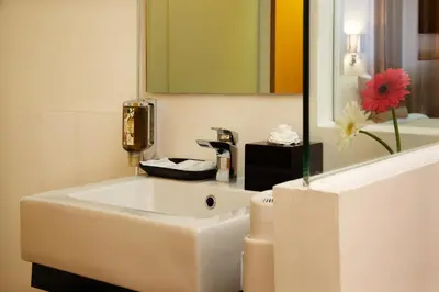 a bathroom with a white sink and a mirror at Citypoint Hotel in Bangkok