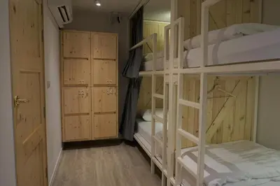 a room with four bunk beds and a hallway at Pinto Hostel in Bangkok