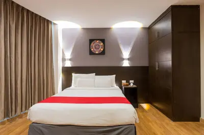a bedroom with a large bed and a clock on the wall at 24@Home Hotel in Nonthaburi