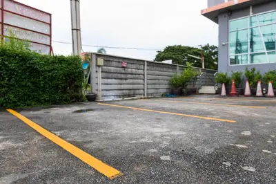 a parking lot with yellow lines in front of a building at 24@Home Hotel in Nonthaburi