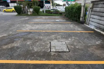 a parking lot with a grate in the ground at 24@Home Hotel in Nonthaburi