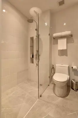a bathroom with a toilet and a glass shower at Red Door Samsen Hotel, Bangkok in Bangkok