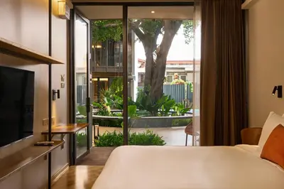 a bedroom with a bed and a large window at Red Door Samsen Hotel, Bangkok in Bangkok