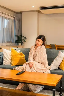 a woman is sitting on a couch at THEA Private Suites by TH District in Bangkok