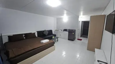 a small room with a bed and a living room at New Room in Nonthaburi