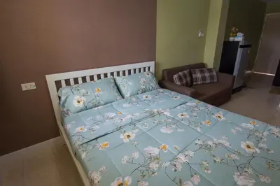 a bed with a blue comforter with flowers on it at Bann In Suan in Ban Lat Tanot
