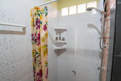 a shower curtain with flowers on it in a bathroom at Bann In Suan in Ban Lat Tanot