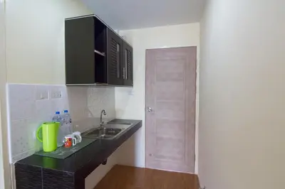 a kitchen with a counter and a sink and a door at Bann In Suan in Ban Lat Tanot