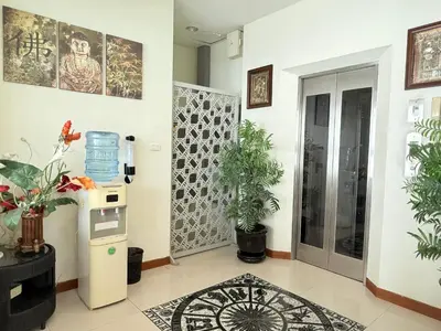 a living room with a refrigerator and potted plants at Bangkok River Loka Hotel in Bangkok