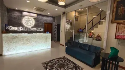 a lobby with a blue couch in a store at Bangkok River Loka Hotel in Bangkok