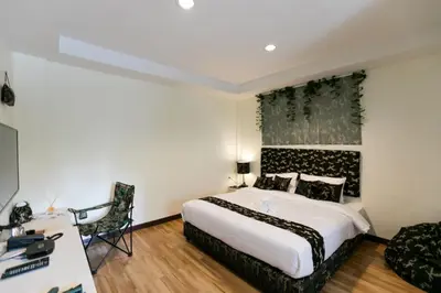 a hotel room with a bed and a desk at Bangkok River Loka Hotel in Bangkok