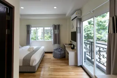 a bedroom with a bed and a balcony at Bangkok River Loka Hotel in Bangkok