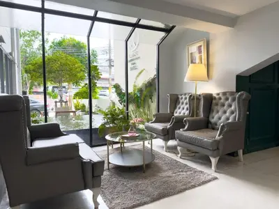 a living room with two chairs and a table at Regent Ramkhamhaeng 22 in Bangkok