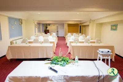 a room with rows of tables and white chairs at Regent Ramkhamhaeng 22 in Bangkok