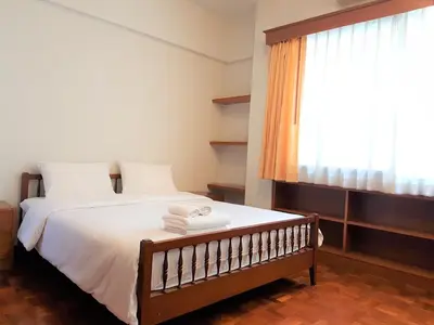 a bedroom with a bed with towels on it at P.T. Court in Bangkok