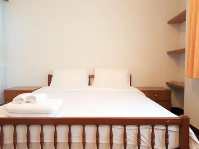 a bed with white sheets and towels on it at P.T. Court in Bangkok