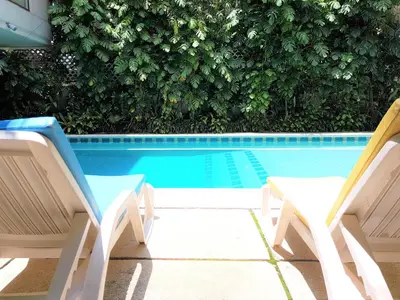 two chairs sitting next to a swimming pool at P.T. Court in Bangkok