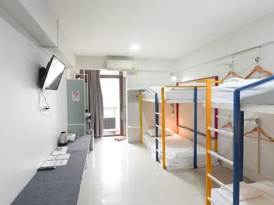 a dorm room with bunk beds and a television at Regent Ngamwongwan Hotel in Nonthaburi