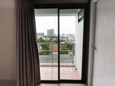 a room with a window with a view of a city at Regent Ngamwongwan Hotel in Nonthaburi