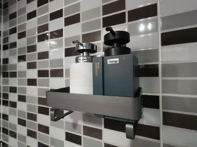 a soap dispenser on a wall in a bathroom at Regent Ngamwongwan Hotel in Nonthaburi