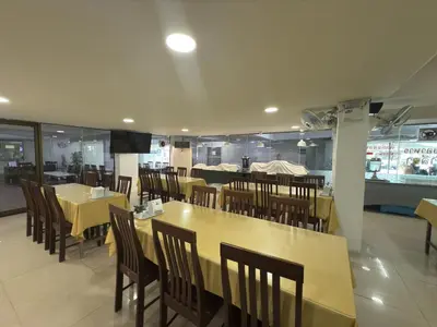 a dining room with tables and chairs in a restaurant at Regent Ngamwongwan Hotel in Nonthaburi