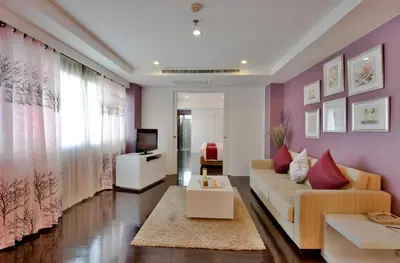 a living room with a couch and a tv at Abloom Exclusive Serviced Apartments in Bangkok