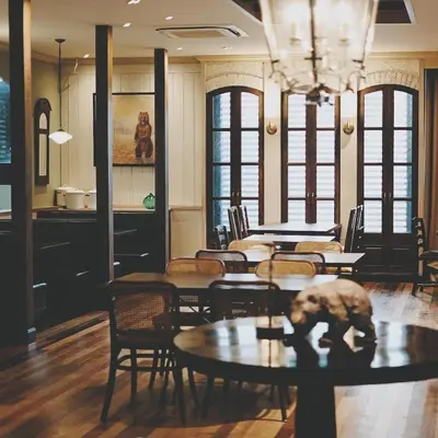 a dining room with tables and chairs and a chandelier at Abloom Exclusive Serviced Apartments in Bangkok