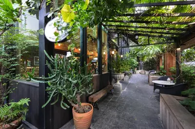 a greenhouse with a lot of plants and benches at Abloom Exclusive Serviced Apartments in Bangkok