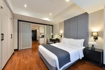 a bedroom with a large bed and a bathroom at Abloom Exclusive Serviced Apartments in Bangkok