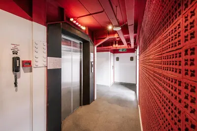 a hallway with red walls and a hallway with a door at Talakkia Boutique Hotel in Bangkok