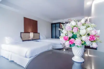 a vase filled with pink and white flowers on a table at Romance Hotel Bangna in Bangkok