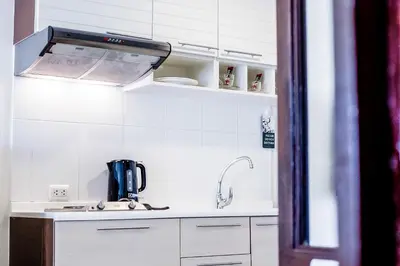 a kitchen with a sink and a coffeemaker at Romance Hotel Bangna in Bangkok