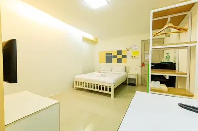 a small room with a bed and a tv at PDA Lord Hotel in Bangkok
