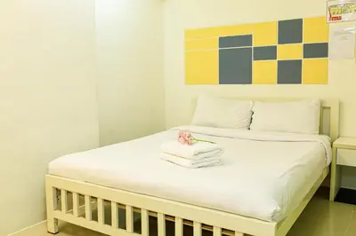 a bed with towels and a flower on it at PDA Lord Hotel in Bangkok