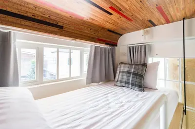 a bed in a room with a wooden ceiling at The Pattern Boutique Hotel in Bangkok