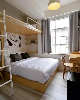 a bedroom with a bunk bed and a window at The Pattern Boutique Hotel in Bangkok
