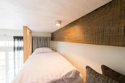 a bedroom with a bed and a wooden wall at The Pattern Boutique Hotel in Bangkok