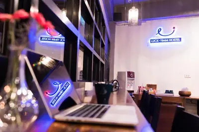 a laptop computer sitting on a table in a restaurant at Luck Yimm Hostel in Bangkok
