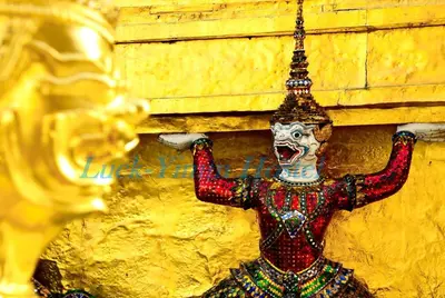 a statue of a mask hanging on a wall at Luck Yimm Hostel in Bangkok