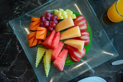 a plate of fruit and vegetables on a table at twothree a homely hotel - SHA Extra Plus in Bangkok