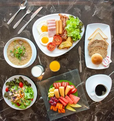 a table topped with plates of food and bowls of food at twothree a homely hotel - SHA Extra Plus in Bangkok