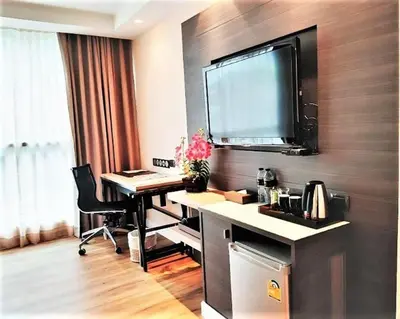 an office with a desk with a monitor on a wall at Amora NeoLuxe Suites Hotel in Bangkok