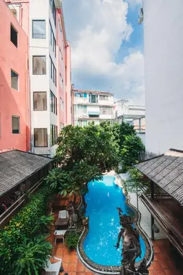 a pool in the middle of a city with buildings at Villa Cha-Cha Banglumphu in Bangkok