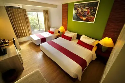 a bedroom with two beds and a green wall at Villa Cha-Cha Banglumphu in Bangkok