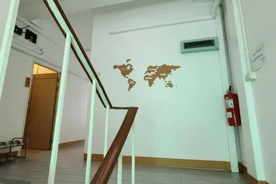 a staircase in a room with a world map on the wall at Ease Hostel in Bangkok