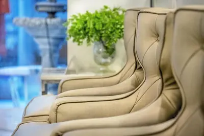 a row of chairs in a room with a plant at De Lavender Bangkok Hotel in Bangkok